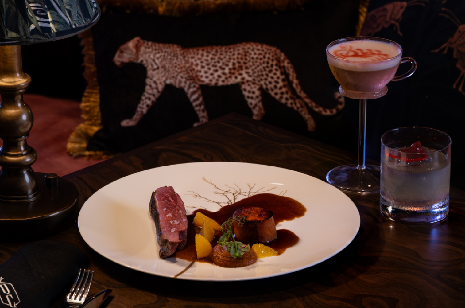 A rich and tender Sous Vide Duck Breast to melt in your mouth with each bite, garnished with sweet potato on the side, a zesty orange jus, and cowboy beans.