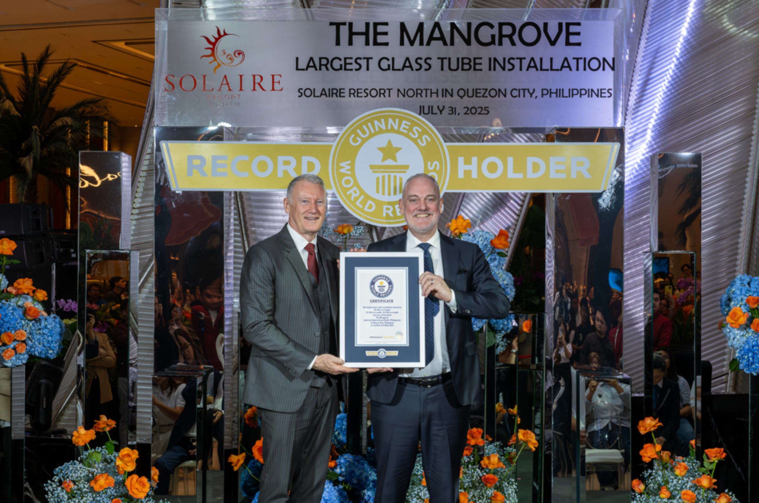 (From L-R) Bloomberry Resorts Corp. President and Chief Operating Officer, Gregory Hawkins and Solaire Resort North Chief Operating Officer Damian Quayle holding the official GUINNESS WORLD RECORDS™ certificate for The Largest Glass Tube Installation