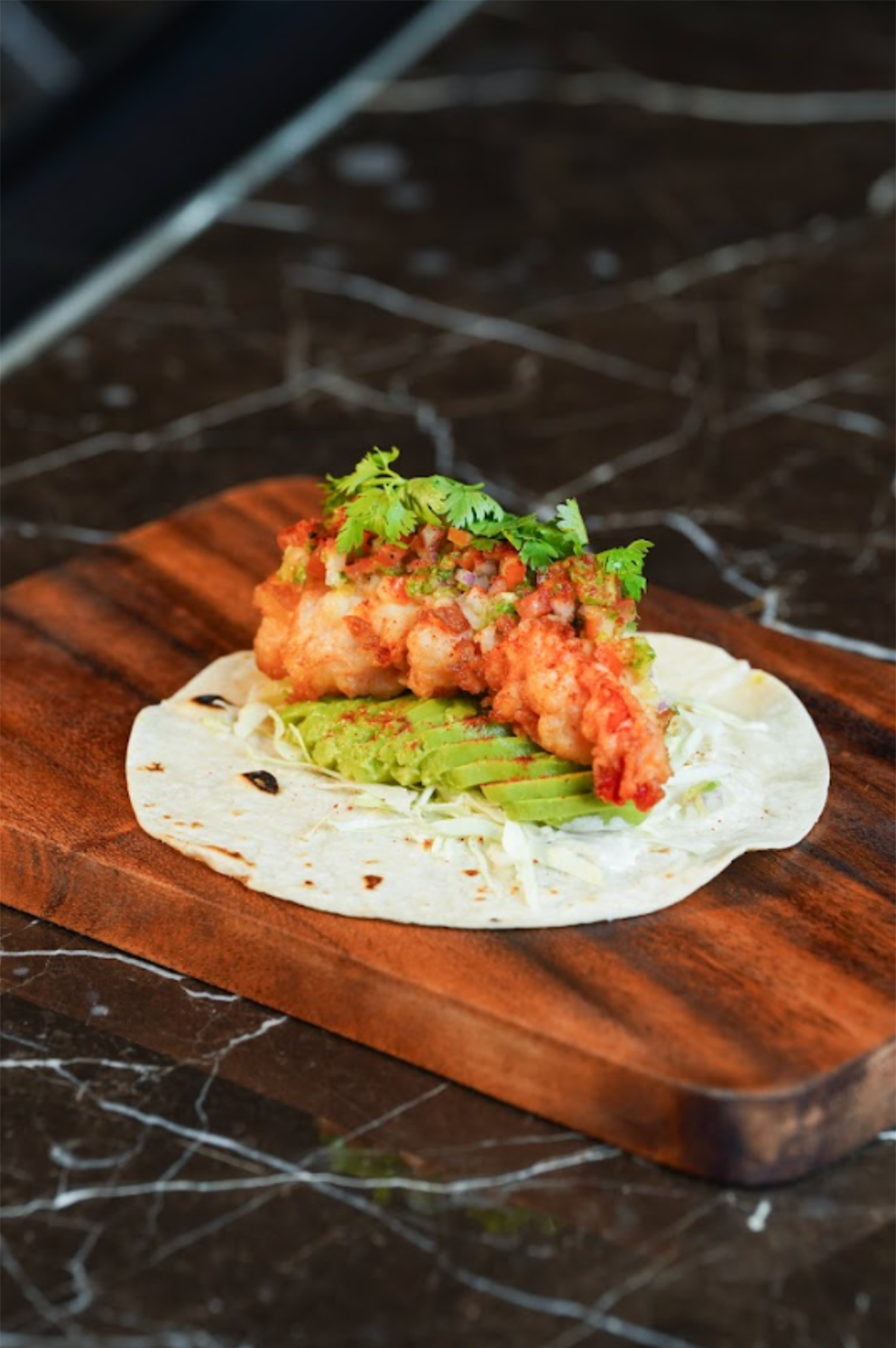 The Just the Way You Are Taco, a bold fusion of prawn tempura, black pepper sour cream, cilantro, and pineapple salsa available at Waterside at Solaire Resort Entertainment City